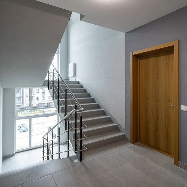 Trapphus med trappa, räcke och ytterdörr i ett flerbostadshus