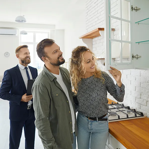 Mäklare visar ett kök för ett par vid en bostadsvisning