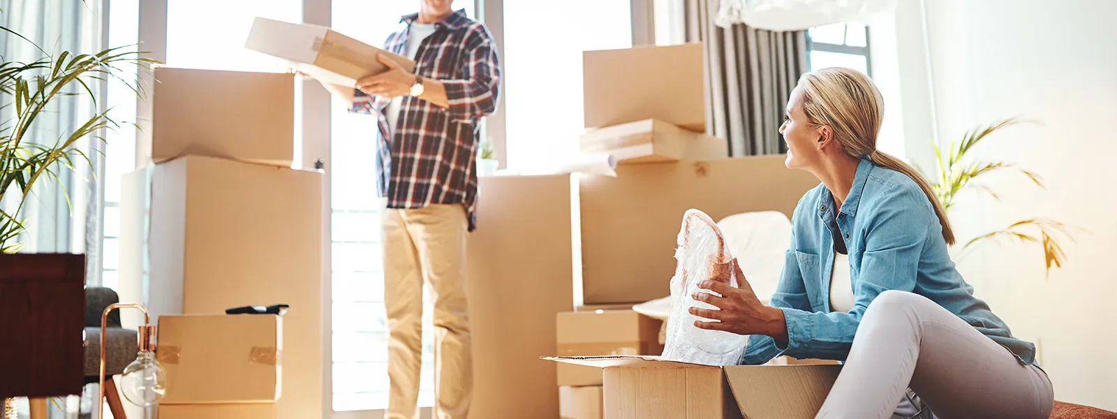 Par packar upp flyttkartonger i sitt nya hem